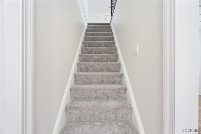 stairs featuring baseboards and carpet