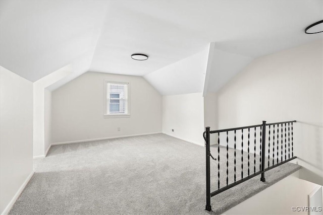 additional living space with carpet floors, baseboards, and lofted ceiling