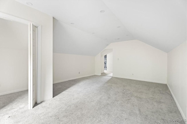 bonus room featuring baseboards, carpet, and vaulted ceiling