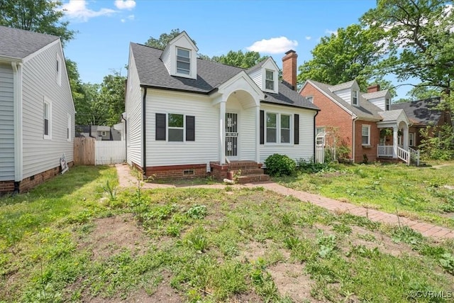 cape cod home featuring a shingled roof, a front lawn, fence, and a chimney