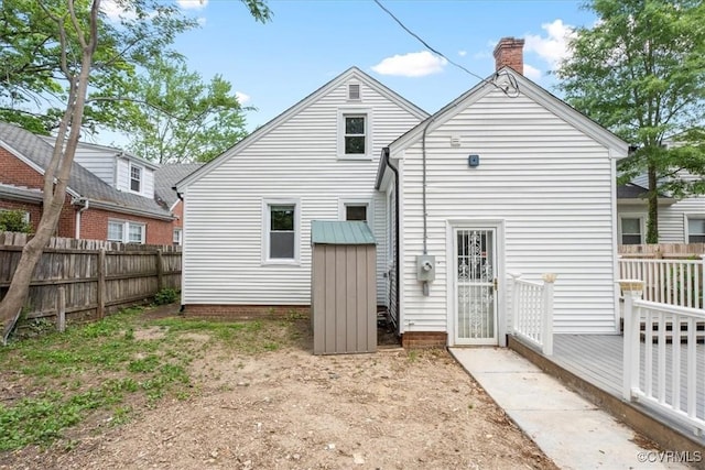 rear view of house with fence and a chimney