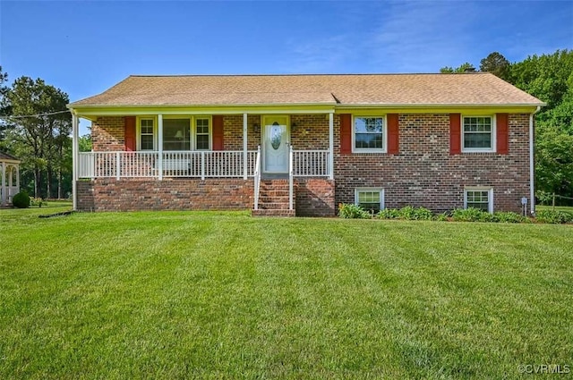 single story home featuring brick siding, covered porch, and a front yard