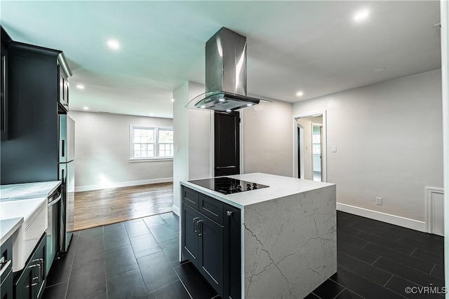 kitchen with exhaust hood, a kitchen island, black electric cooktop, baseboards, and recessed lighting