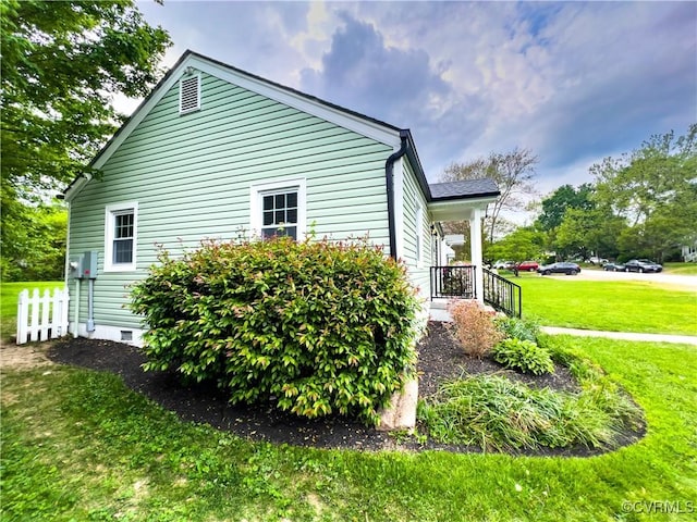 view of side of home featuring a yard and crawl space