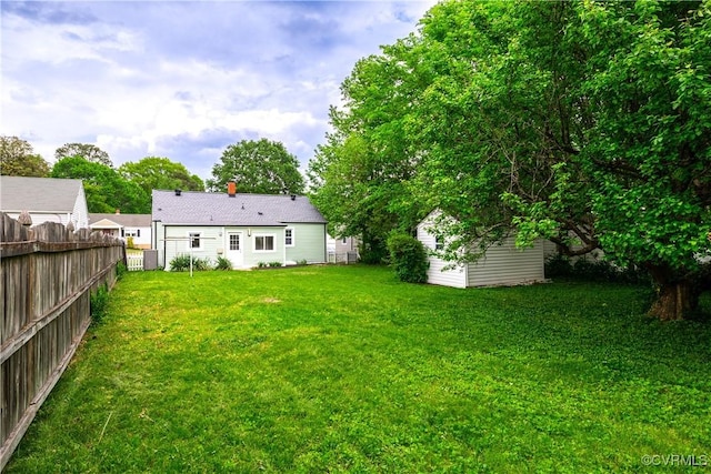 view of yard featuring fence and an outbuilding