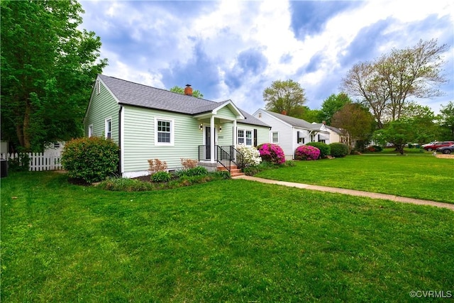 view of front of property with fence, a chimney, roof with shingles, and a front lawn