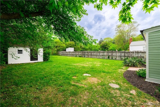view of yard featuring fence and an outbuilding