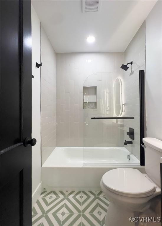 bathroom with toilet,  shower combination, and visible vents