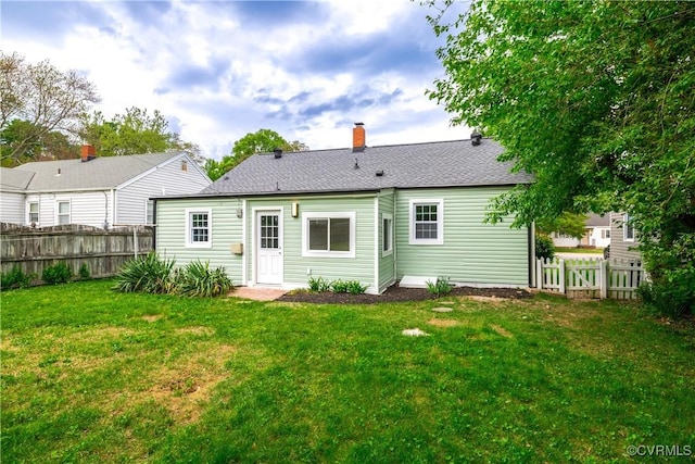 6503 W Grace St, Henrico, VA 23226 - back of property featuring a fenced backyard, a chimney, and roof with shingles