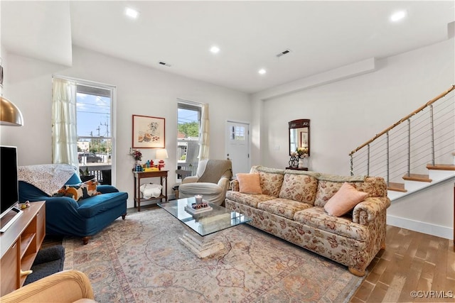 living area featuring recessed lighting, visible vents, wood finished floors, and stairway
