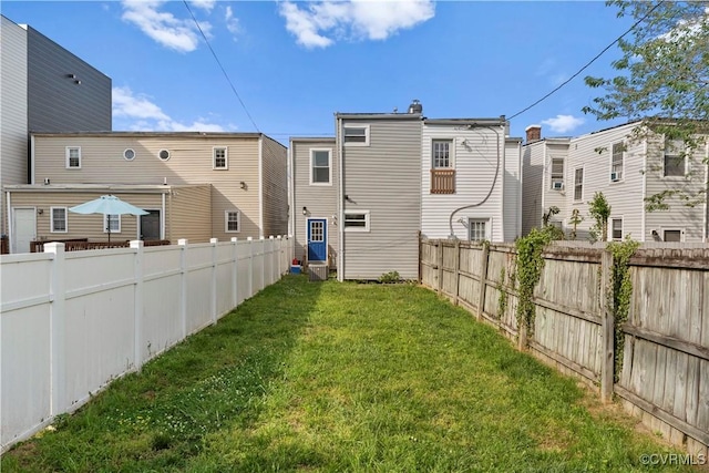 back of property featuring a lawn and a fenced backyard