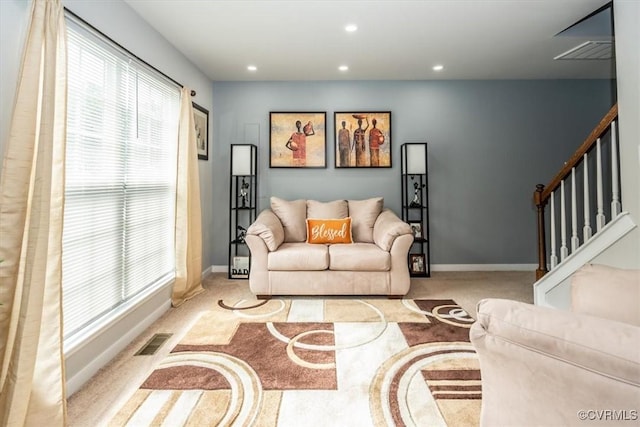 living area with visible vents, plenty of natural light, and carpet