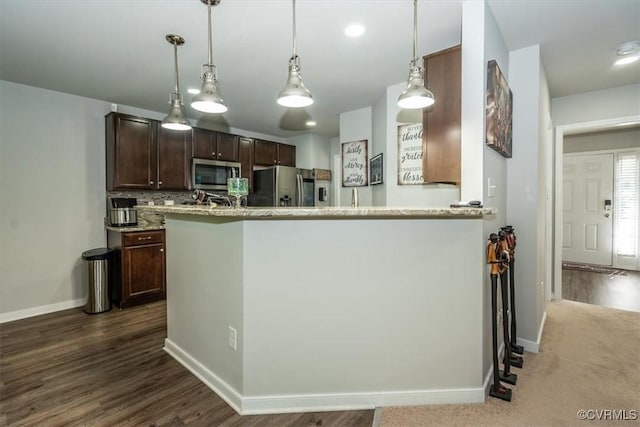 kitchen featuring baseboards, decorative light fixtures, stainless steel appliances, and dark brown cabinets