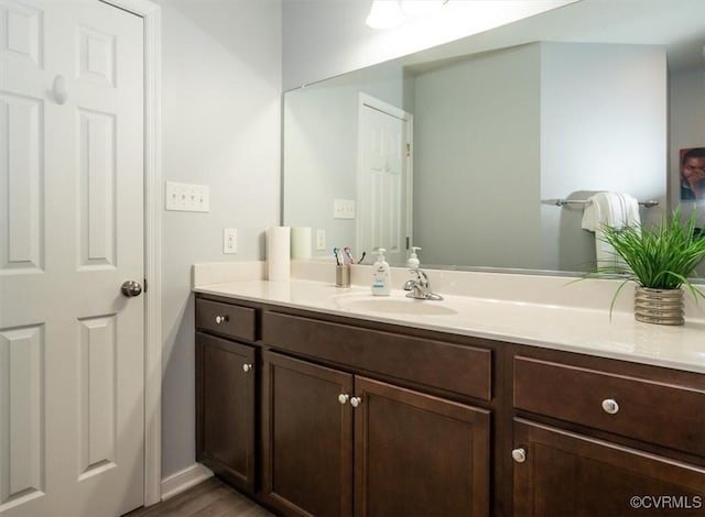 bathroom featuring vanity, baseboards, and wood finished floors