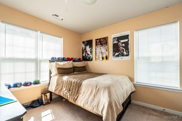 bedroom featuring carpet floors, visible vents, and multiple windows
