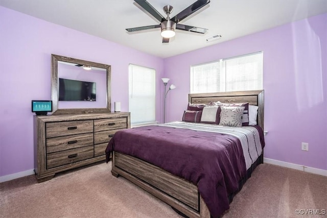 carpeted bedroom featuring baseboards, a ceiling fan, and visible vents