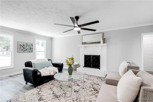 7713 Flag Tail Dr, Midlothian, VA 23112 - living area with crown molding, wood finished floors, a ceiling fan, a fireplace, and baseboards