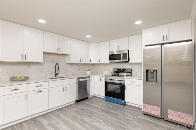 1701 Arlington Rd, Hopewell, VA 23860 - kitchen featuring a sink, decorative backsplash, stainless steel appliances, and white cabinetry