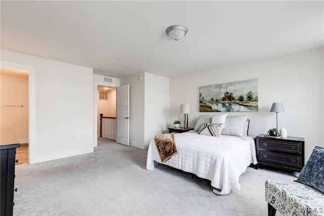 bedroom featuring baseboards, light colored carpet, and visible vents