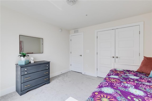 bedroom featuring baseboards, light colored carpet, visible vents, and a closet