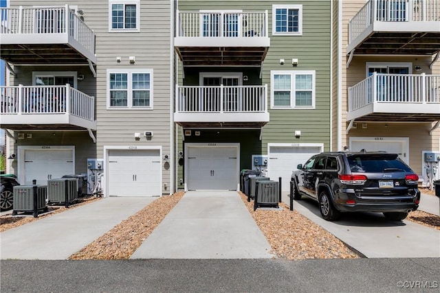 exterior space with a garage, central air condition unit, and driveway