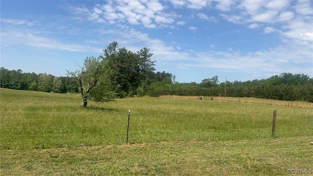 view of yard featuring a rural view and a wooded view