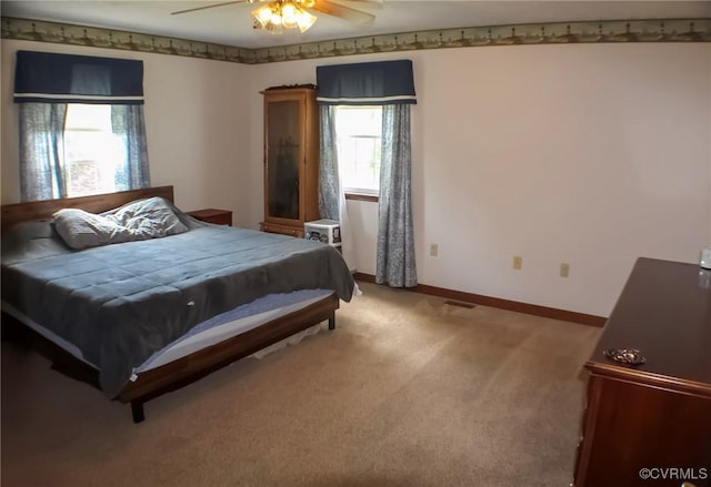 bedroom featuring baseboards, ceiling fan, visible vents, and light carpet