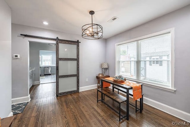 dining space with baseboards, dark wood finished floors, a barn door, and plenty of natural light