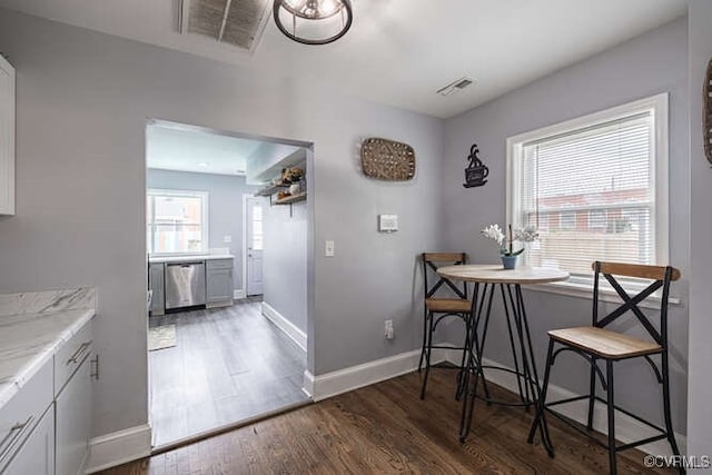 dining room with baseboards, wood finished floors, and visible vents
