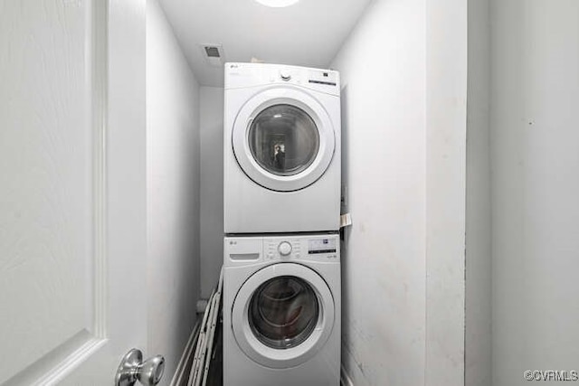 clothes washing area with stacked washer / drying machine and laundry area