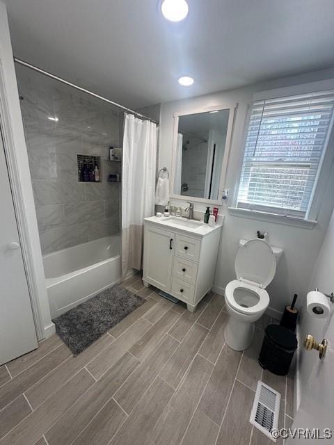 2789 Sussex Dr, Emporia, VA 23847 - full bathroom with vanity, shower / bath combo with shower curtain, visible vents, and wood tiled floor