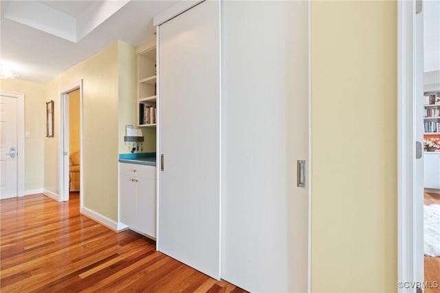 hallway with baseboards and light wood-style flooring