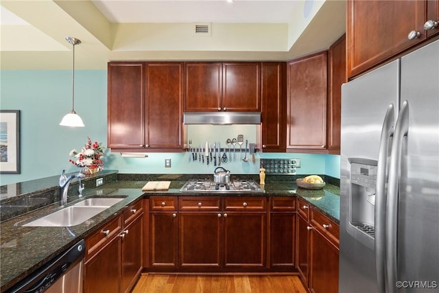 kitchen with visible vents, dark stone counters, a sink, light wood-style flooring, and stainless steel appliances