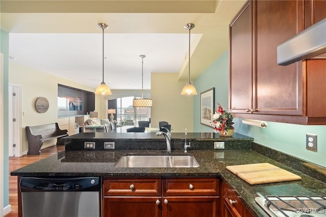 kitchen featuring a peninsula, open floor plan, under cabinet range hood, a sink, and appliances with stainless steel finishes