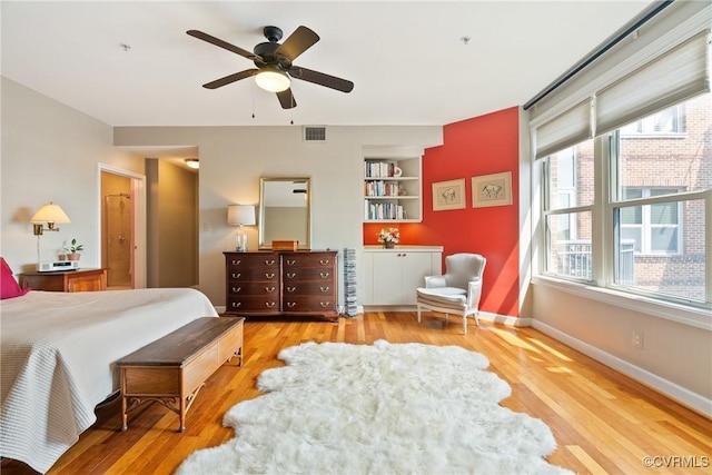 bedroom with visible vents, baseboards, ceiling fan, and wood finished floors