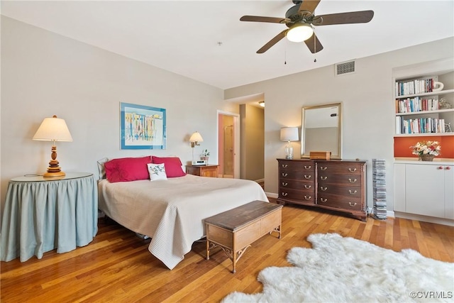 bedroom featuring ceiling fan, visible vents, and wood finished floors