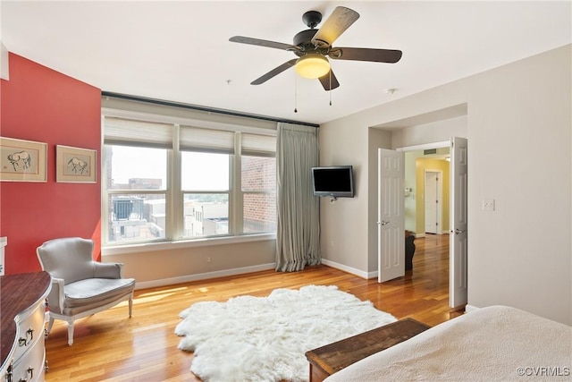 bedroom featuring baseboards, ceiling fan, and light wood finished floors