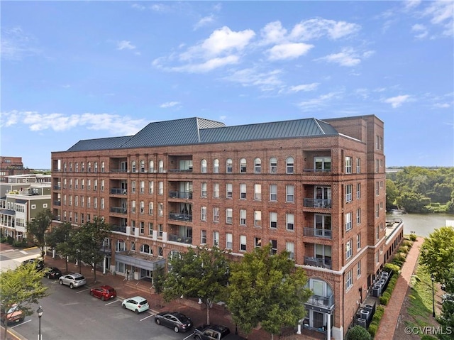 view of property featuring uncovered parking and central air condition unit