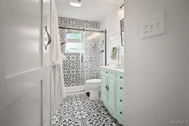 full bathroom with vanity, toilet, and tiled shower