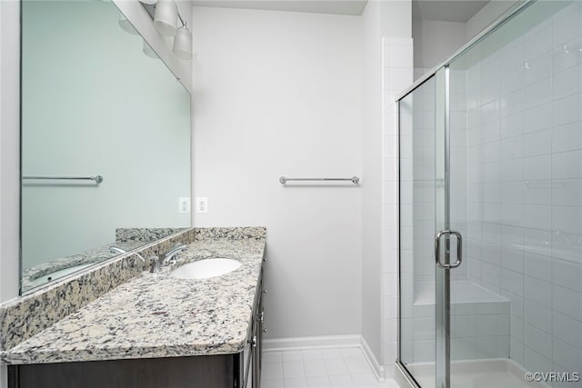 full bath with vanity, baseboards, and a stall shower