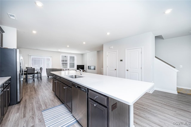 kitchen with visible vents, open floor plan, light wood-type flooring, light countertops, and stainless steel appliances