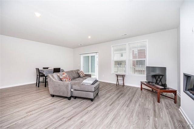 living room featuring baseboards and light wood-type flooring