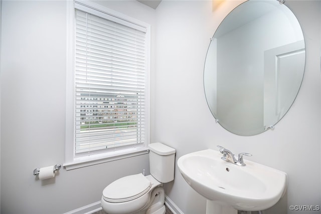 bathroom with toilet, baseboards, and a sink