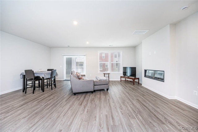 living area with baseboards, recessed lighting, wood finished floors, and visible vents