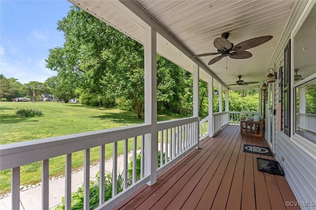 deck with a ceiling fan, a porch, and a lawn
