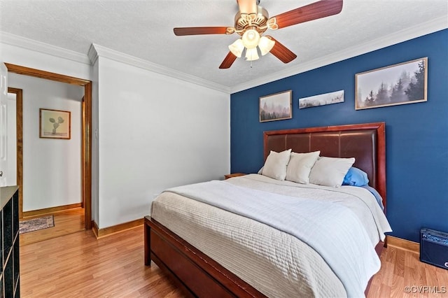 bedroom featuring ceiling fan, crown molding, baseboards, and wood finished floors
