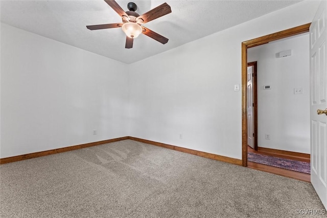 unfurnished room featuring a ceiling fan, carpet floors, and baseboards