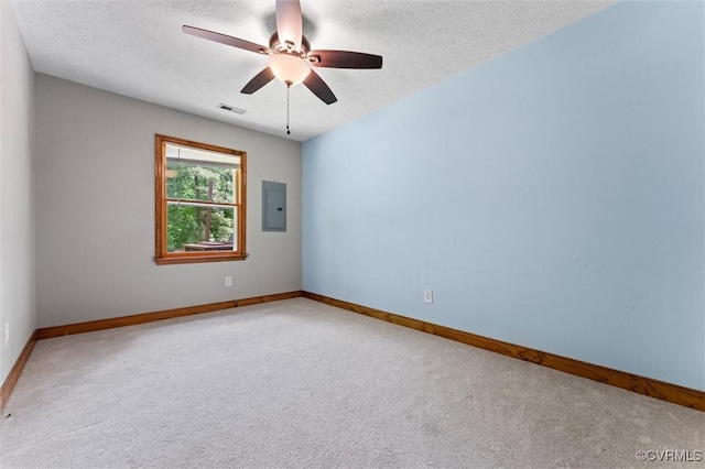 carpeted empty room featuring electric panel, visible vents, baseboards, and ceiling fan