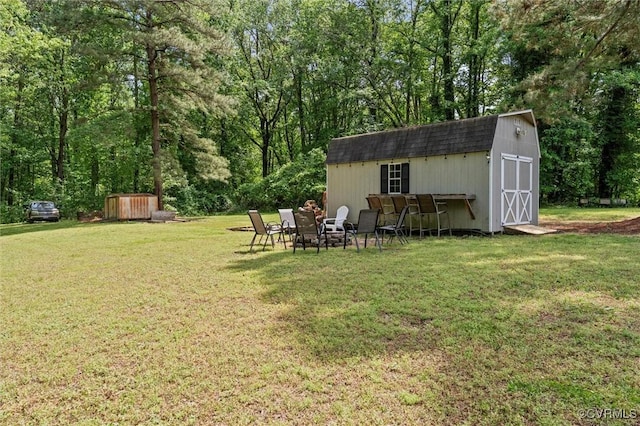 view of grassy yard with a storage unit and an outdoor structure