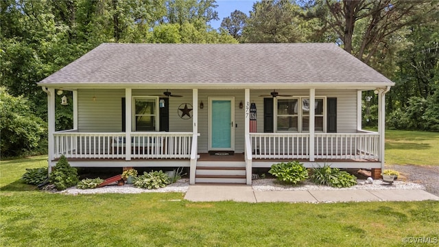 view of front of property featuring covered porch, a ceiling fan, a front yard, and roof with shingles